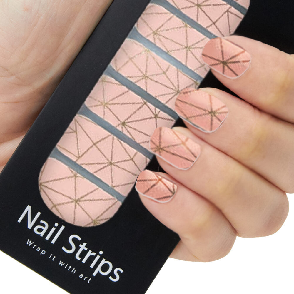 Refect Beauty Yolo nail strips featuring a soft pink geometric pattern with gold lines applied to fingernails