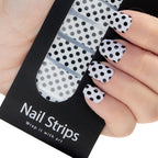 Refect Beauty Yolo nail strips featuring a black and white polka dot pattern applied to fingernails
