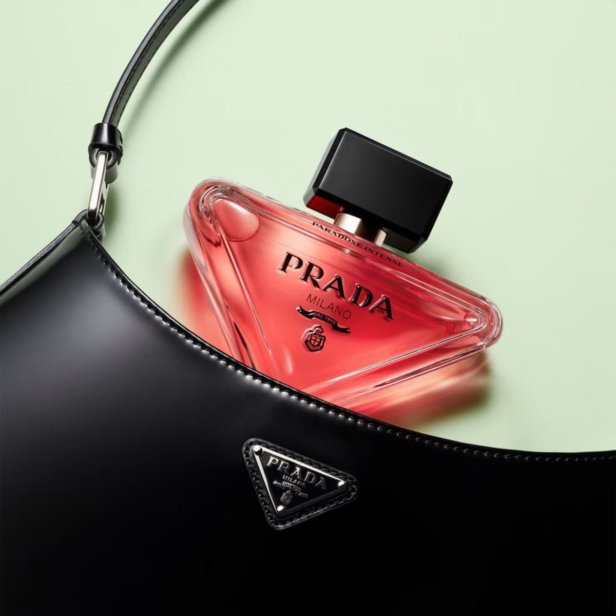 Refect Beauty Prada Paradoxe Intense perfume bottle in a triangular pink glass design resting inside a black bag