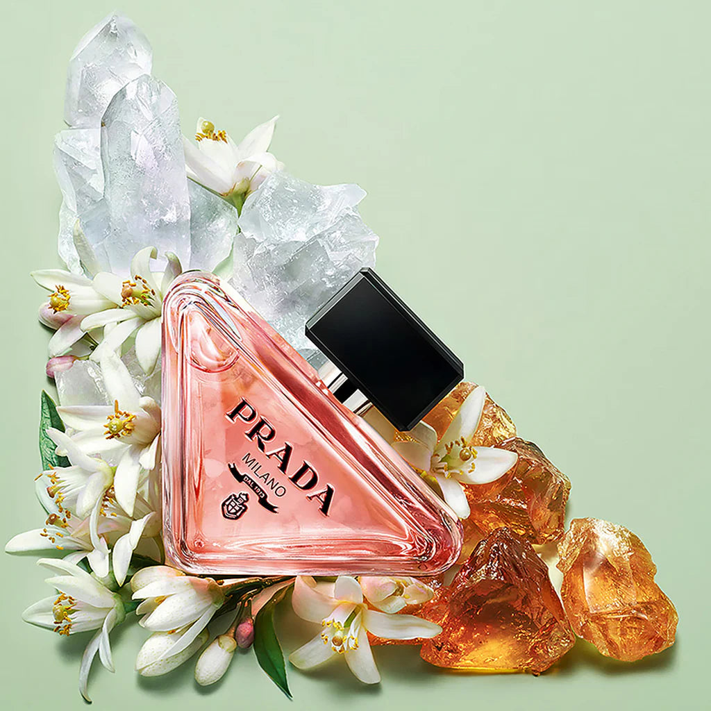Refect Beauty Prada Paradoxe Eau de Parfum in a triangular glass bottle surrounded by orange blossoms and crystals