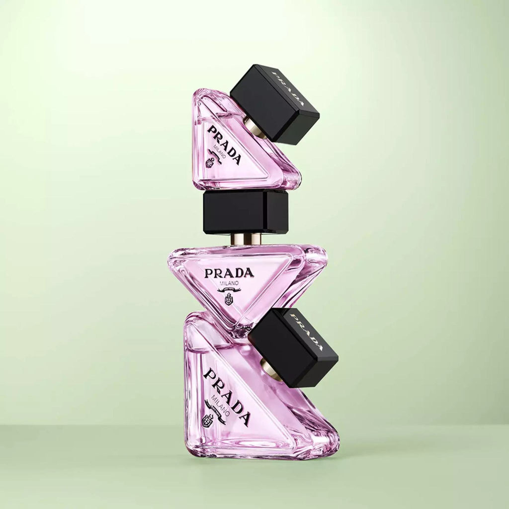 Refect Beauty Prada Paradoxe Virtual Flower perfume bottles stacked in a triangular arrangement on a green background