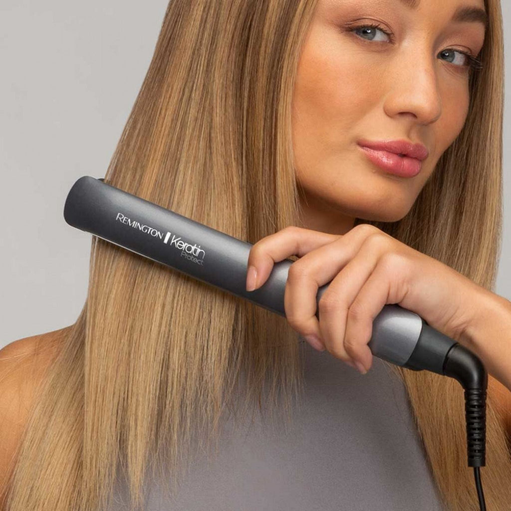 Refect Beauty Remington Keratin Protect hair straightener being used by a woman to style her long, smooth blonde hair.