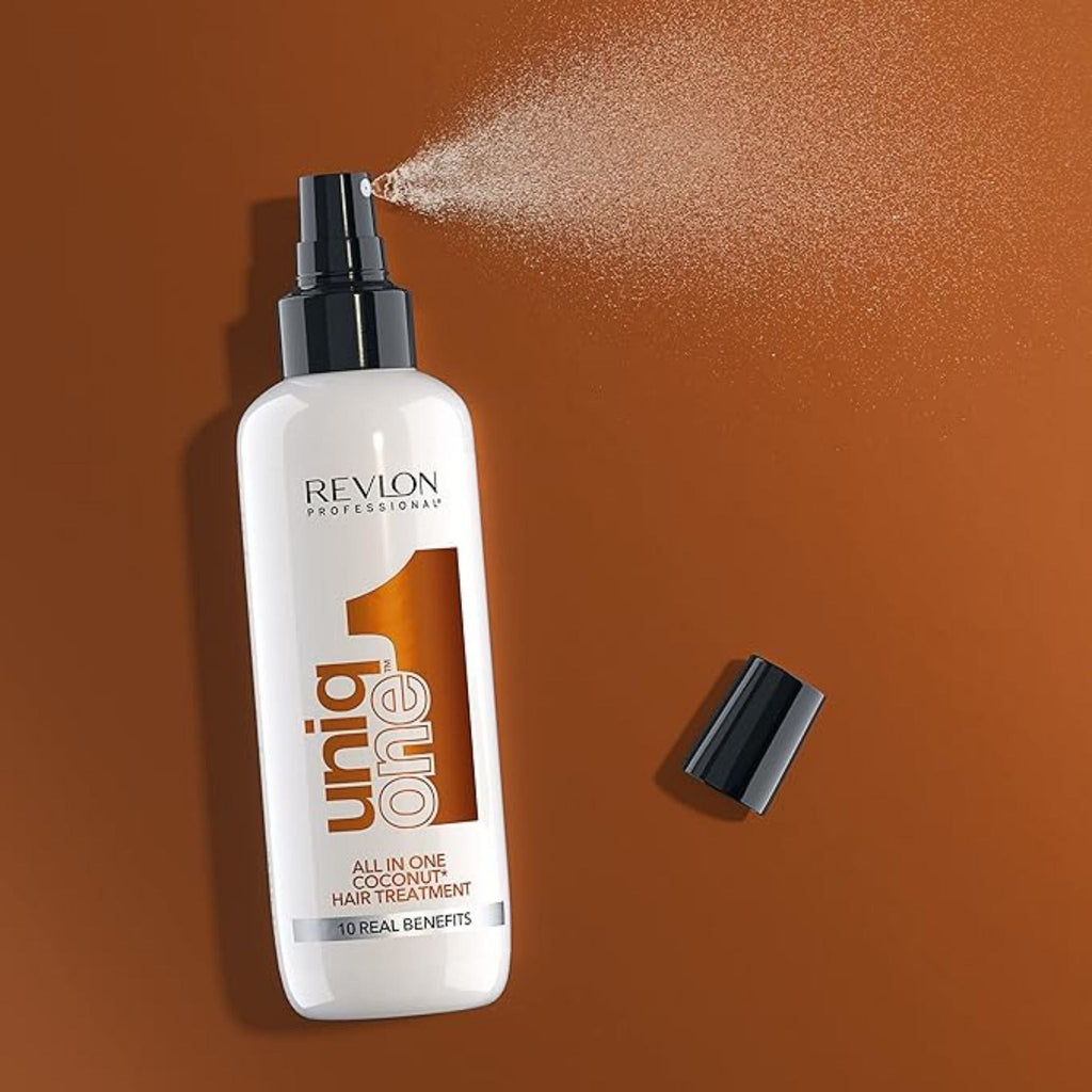 Refect Beauty Revlon Uniq One Coconut leave-in hair treatment spray bottle with mist on a brown background