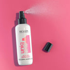 Refect Beauty Revlon Uniq One Lotus Flower leave-in hair treatment spray bottle on a vibrant pink background