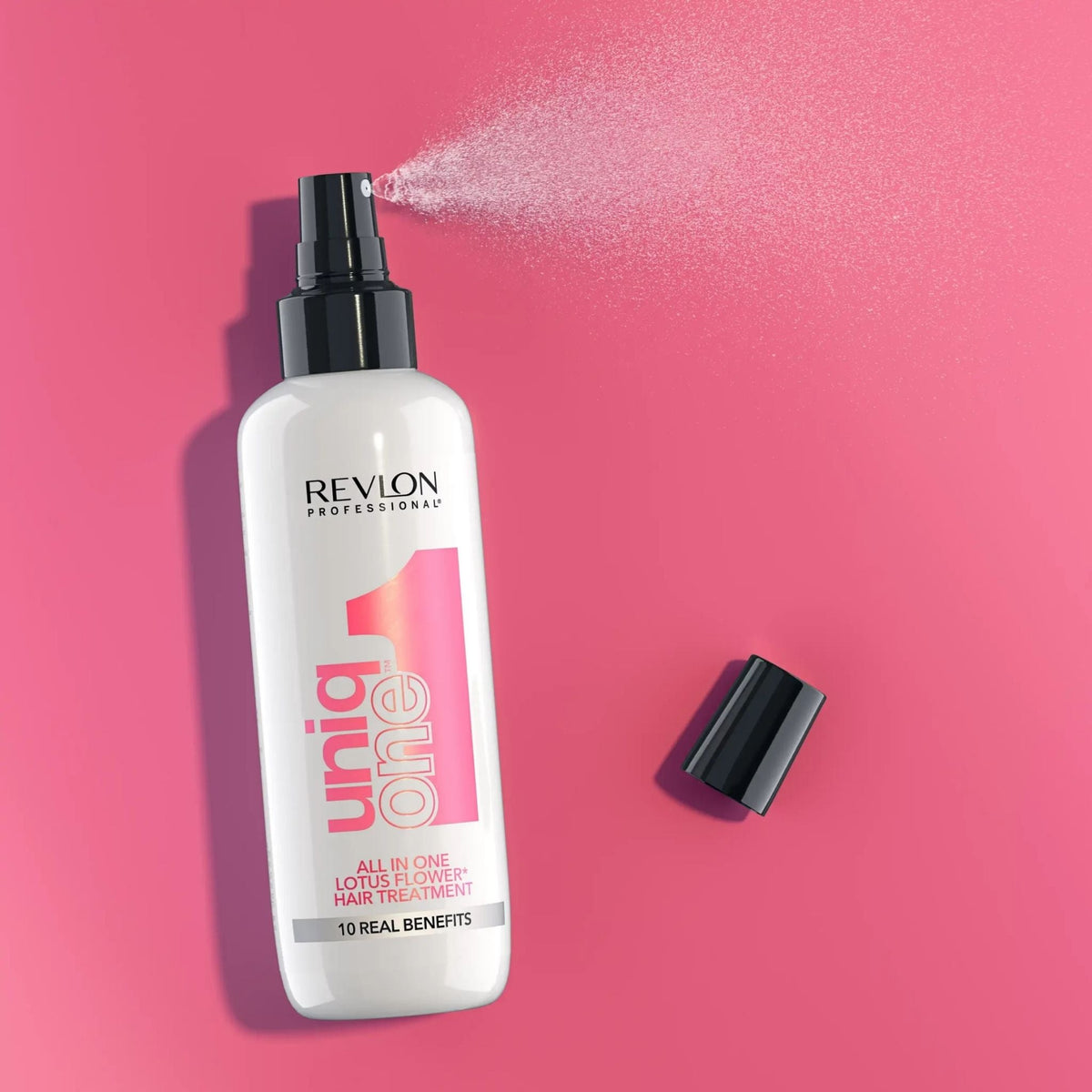 Refect Beauty Revlon Uniq One Lotus Flower leave-in hair treatment spray bottle on a vibrant pink background
