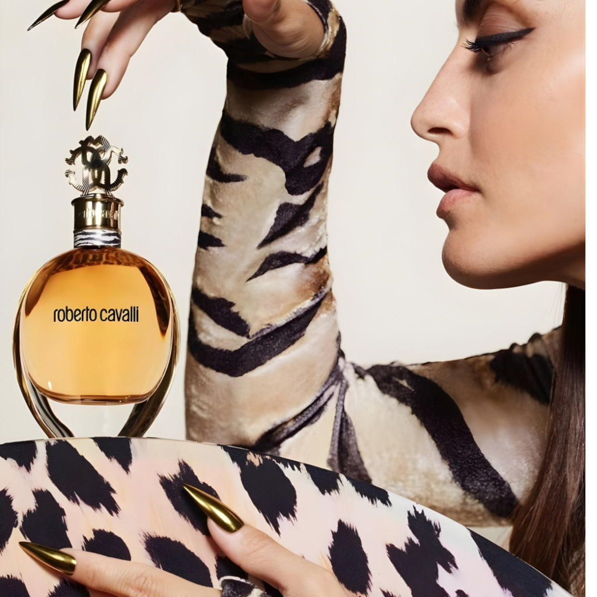 Refect Beauty Roberto Cavalli Eau de Parfum bottle held by a woman wearing a tiger print top with gold nails