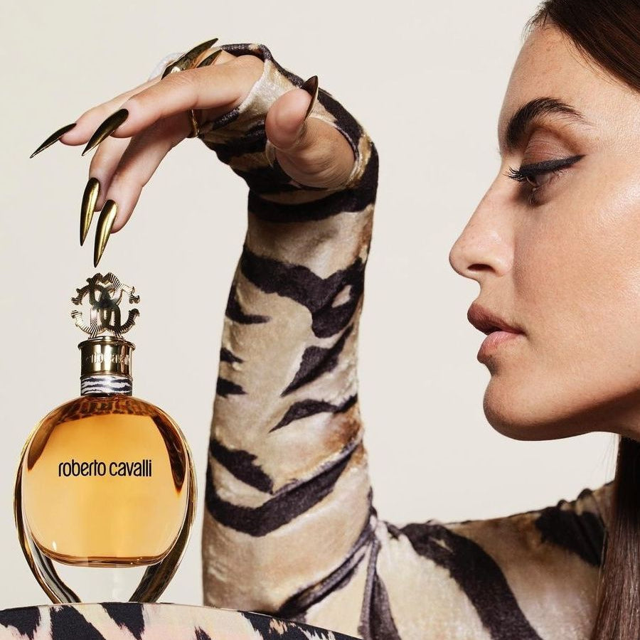 Refect Beauty Roberto Cavalli Eau de Parfum bottle held by a woman wearing a tiger print top
