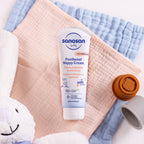 Refect Beauty Sanosan Baby Panthenol Nappy Cream tube on soft pastel muslin cloths with a plush toy