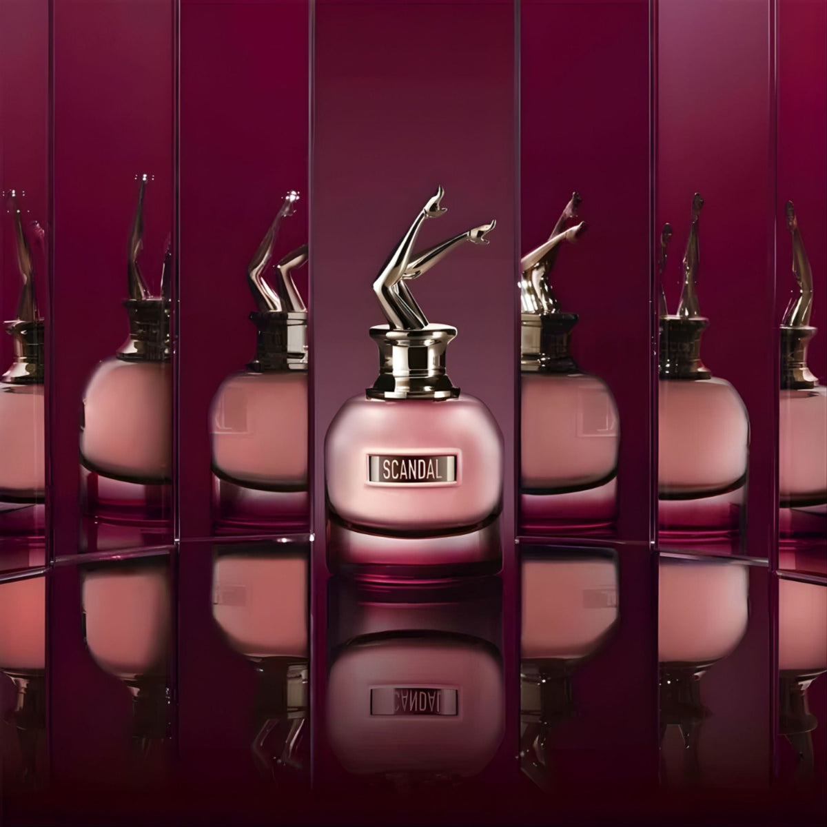 Refect Beauty Jean Paul Gaultier Scandal By Night perfume bottle with iconic gold legs cap against mirrored background
