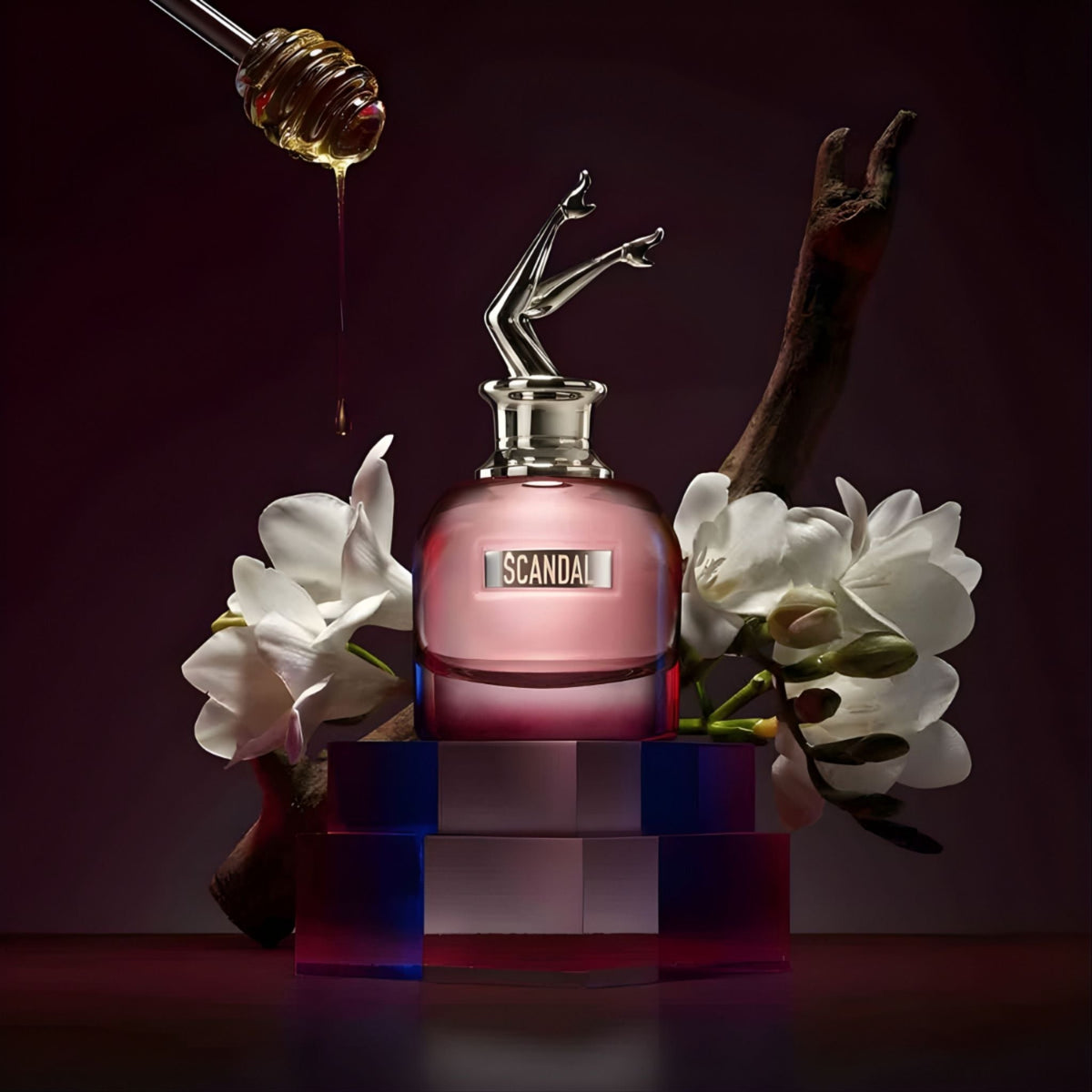 Refect Beauty Jean Paul Gaultier Scandal By Night perfume bottle with honey dipper, white flowers, and wooden branch