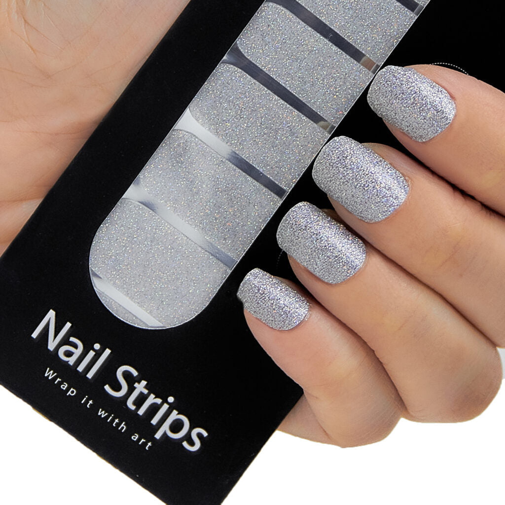 Refect Beauty Yolo silver glitter nail strips applied to fingers for a sparkling salon-style manicure look.