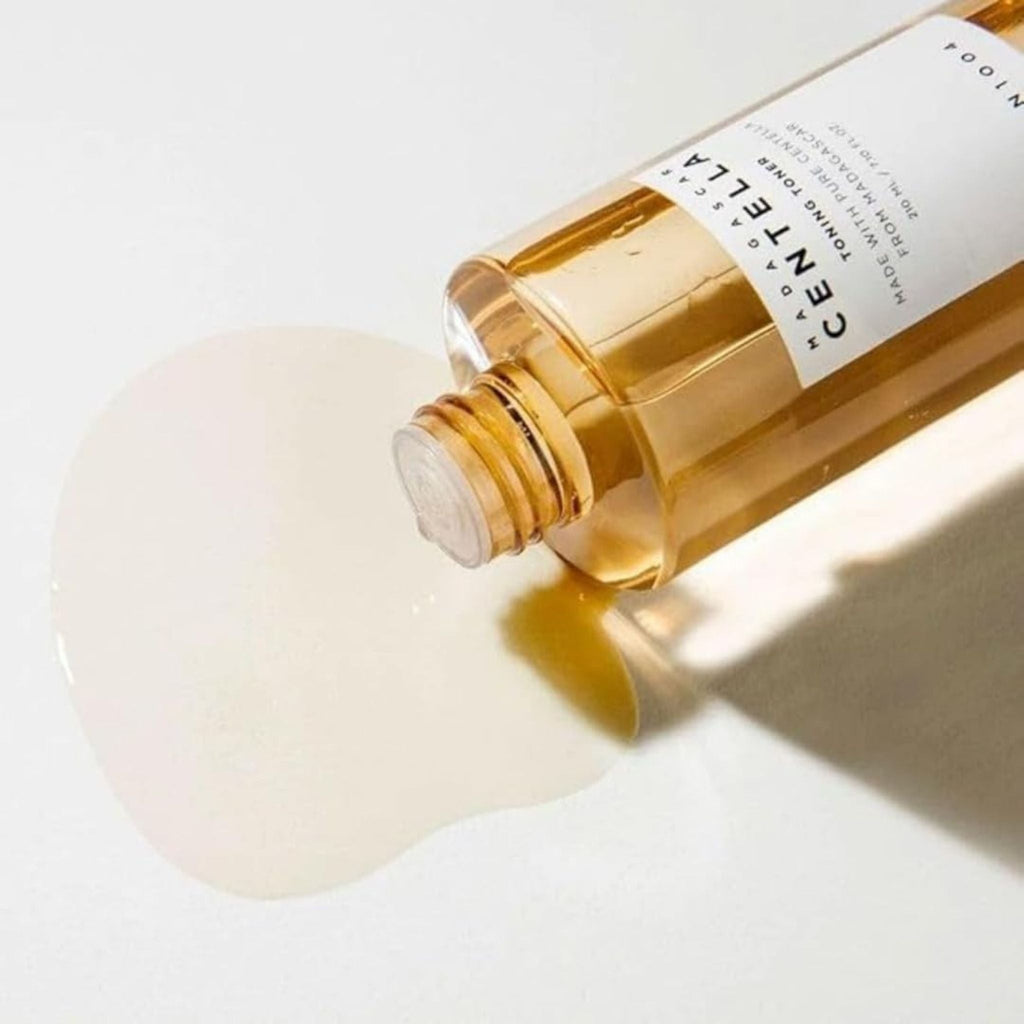 Refect Beauty SKIN1004 Centella Toning Toner with light brown watery texture spilling on a white surface