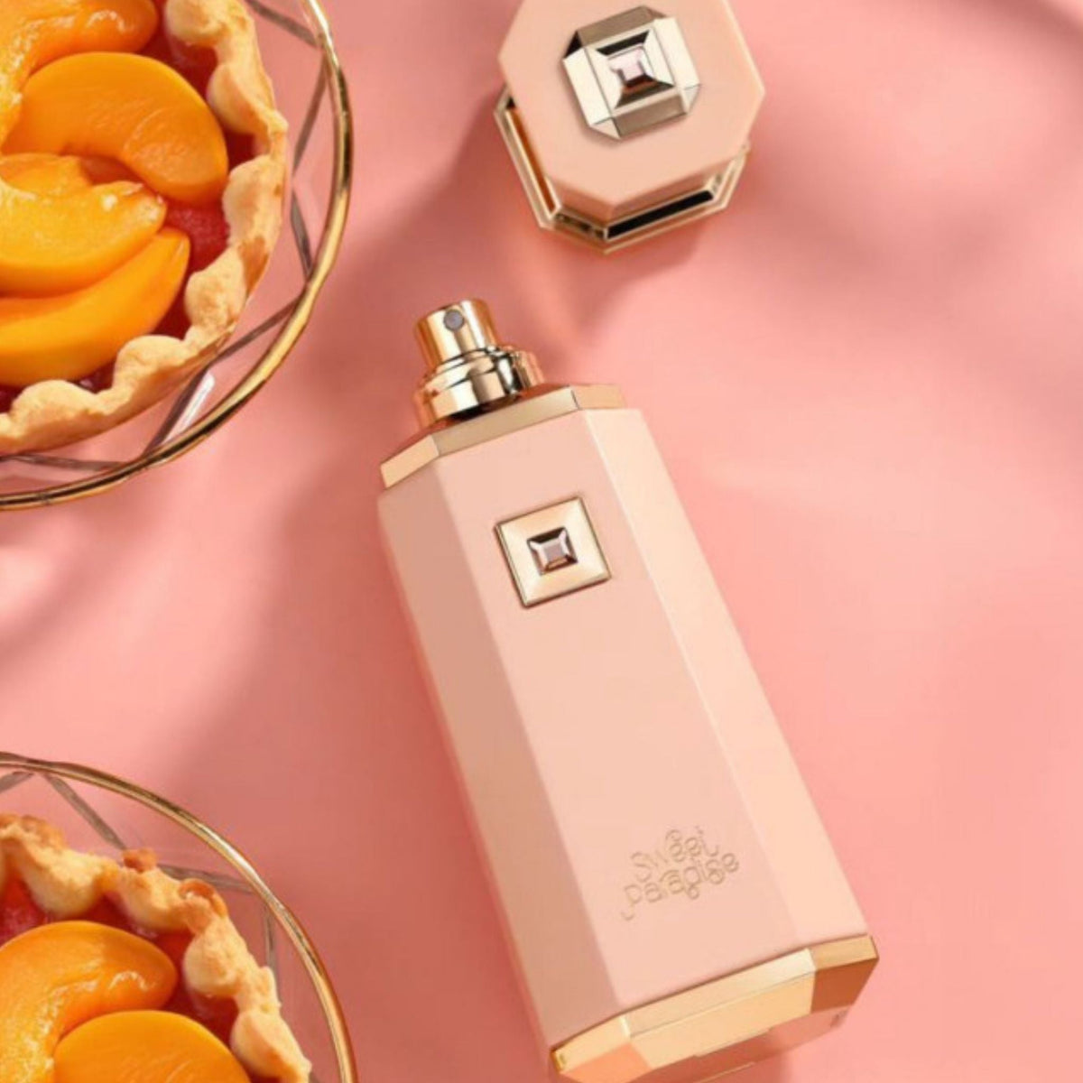Refect Beauty French Avenue Sweet Paradise perfume bottle in soft pink with gold accents next to peach tarts