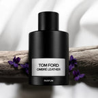 Refect Beauty Tom Ford Ombre Leather Parfum bottle resting on a rustic wooden branch with purple violet flowers