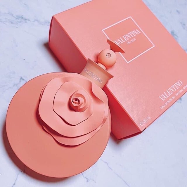 Refect Beauty Valentino Blush eau de parfum bottle with a coral rose cap next to its matching square perfume box
