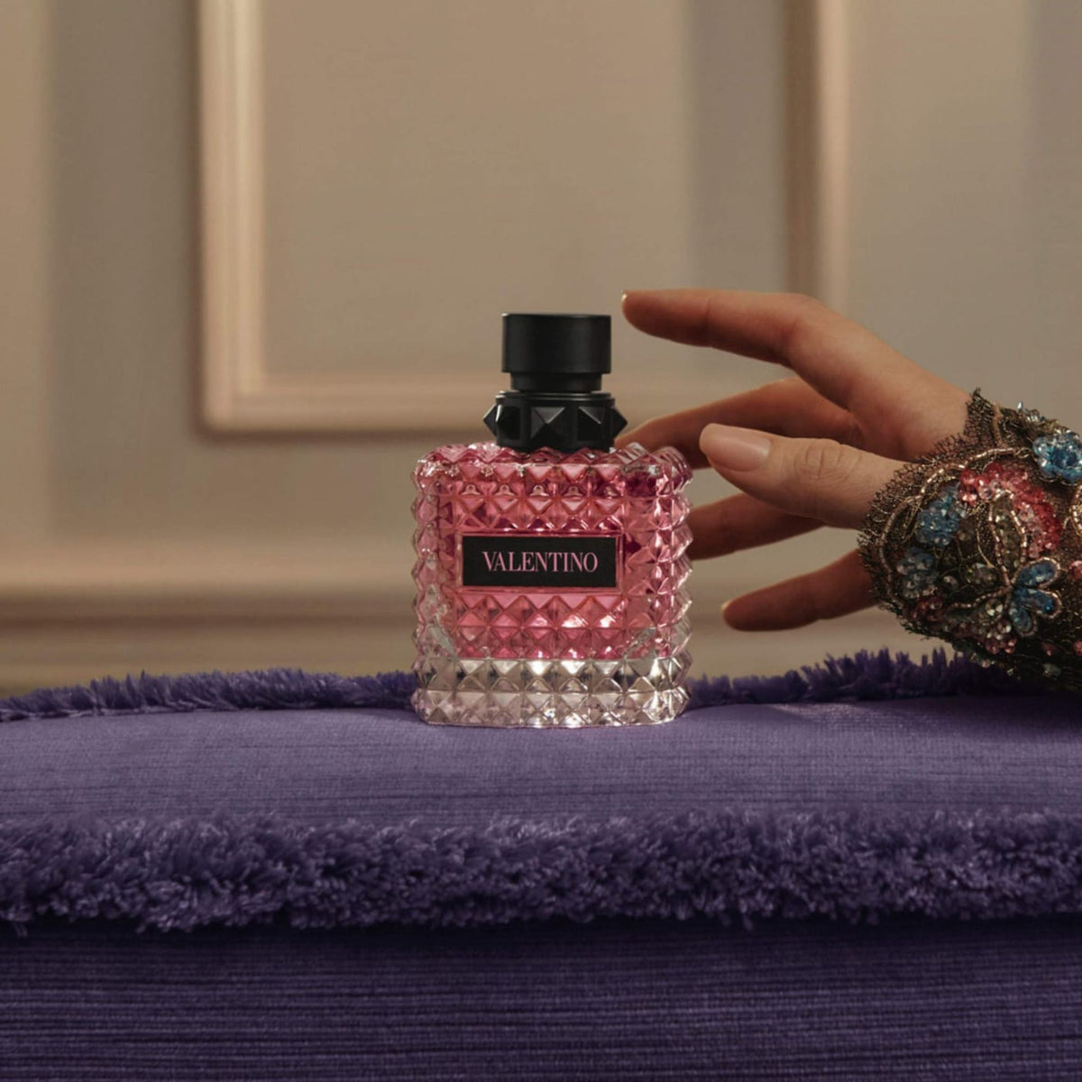 Refect Beauty Valentino Donna Born In Roma perfume bottle with pink glass and stud texture on a purple velvet surface