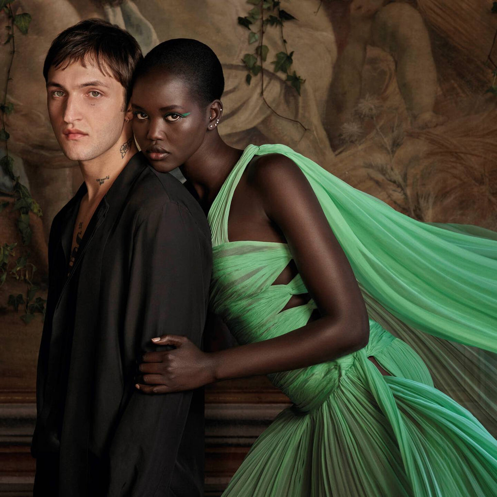 Refect Beauty campaign featuring a man in black and a woman in a flowing green pleated dress for Valentino fragrance