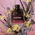Refect Beauty Valentino Uomo Born In Roma Intense perfume bottle surrounded by orchids and lavender on pink background