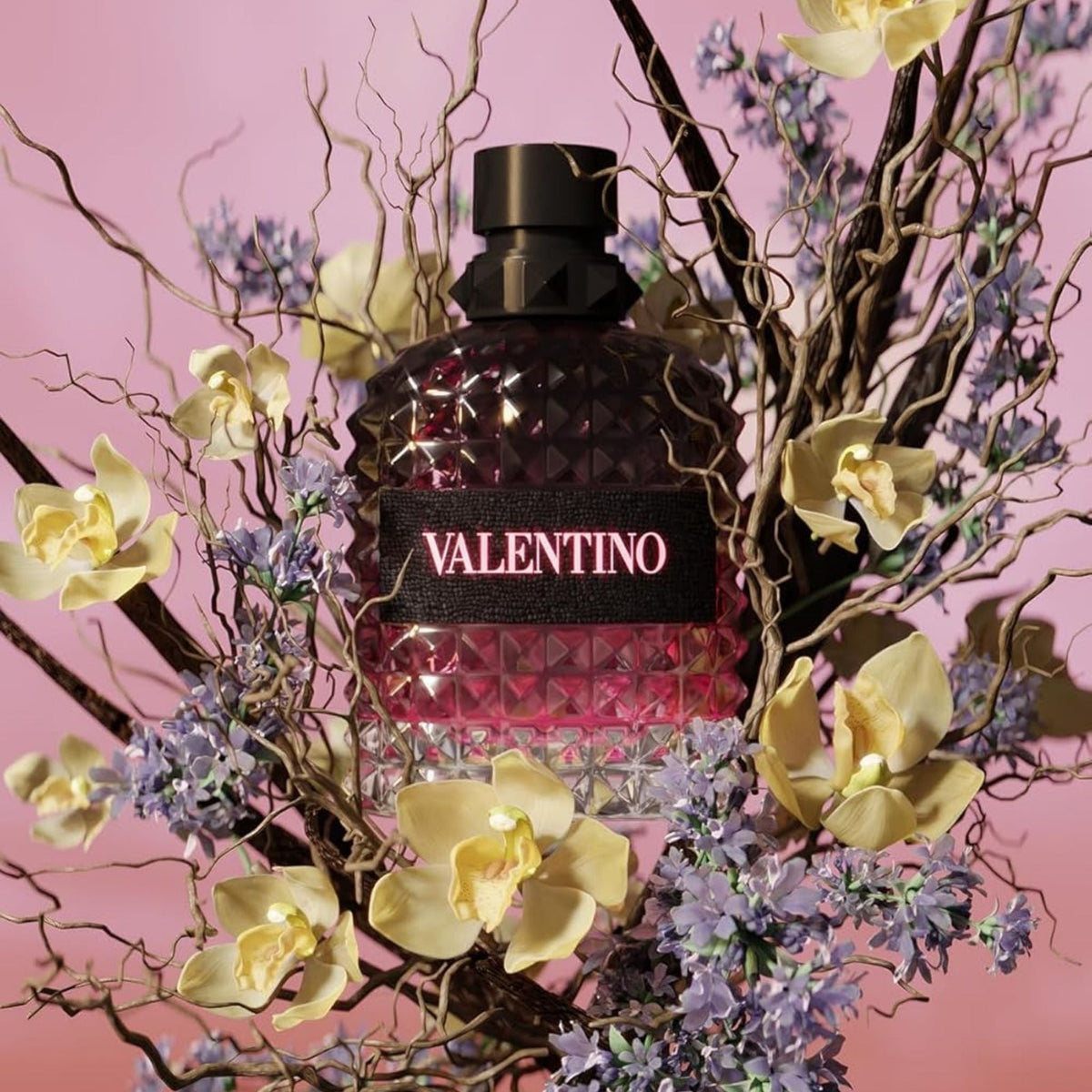 Refect Beauty Valentino Uomo Born In Roma Intense perfume bottle surrounded by orchids and lavender on pink background