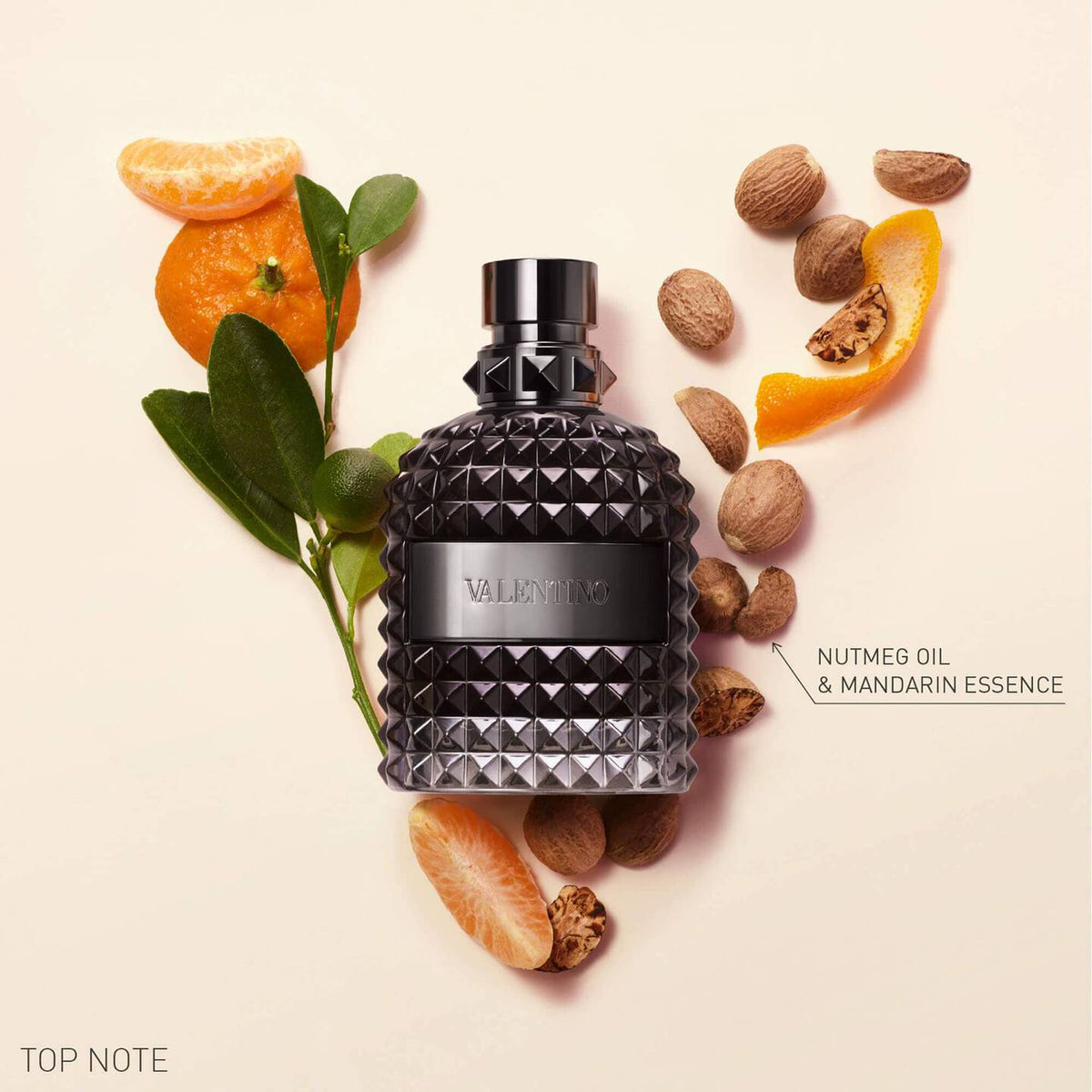 Refect Beauty Valentino Uomo Intense perfume bottle surrounded by mandarin orange slices and nutmeg on a beige background
