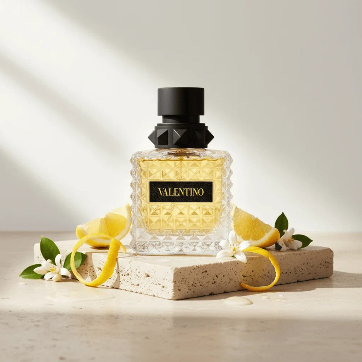Refect Beauty Valentino Donna Born In Roma Yellow Dream perfume bottle with lemon slices and flowers on stone base
