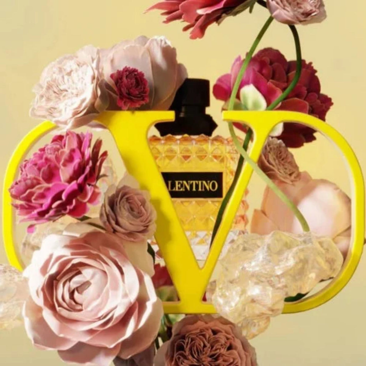 Refect Beauty Valentino Donna Born In Roma Yellow Dream perfume bottle surrounded by pink roses and a yellow V logo