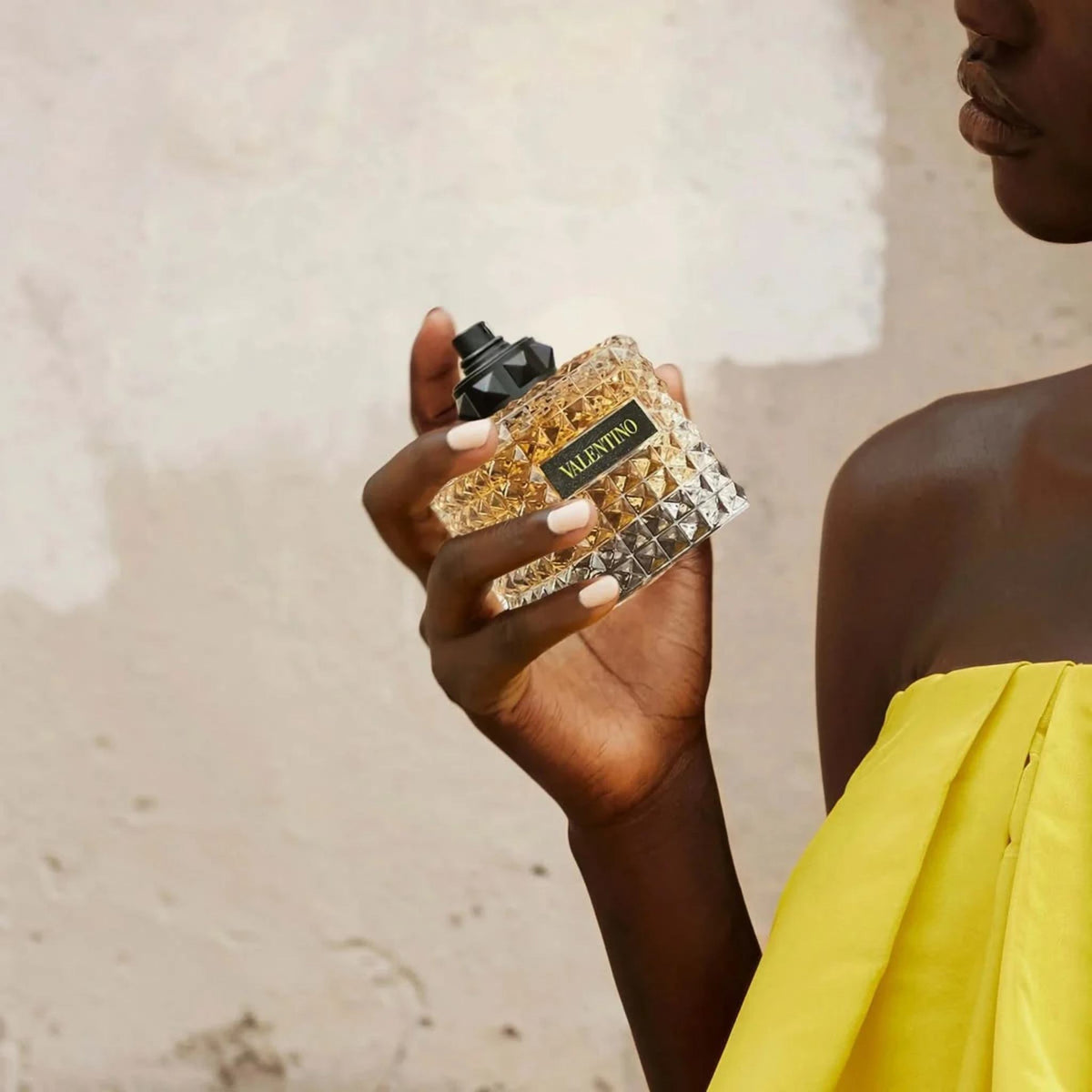 Refect Beauty Valentino Donna Born In Roma Yellow Dream perfume bottle held by a woman in a yellow dress
