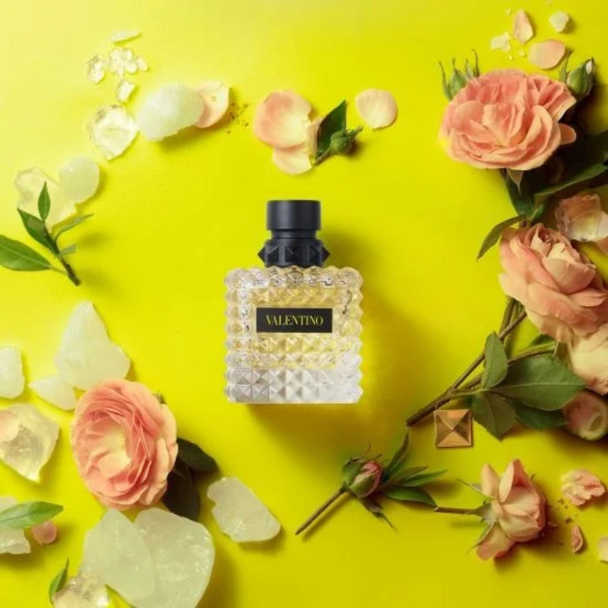 Refect Beauty Valentino Donna Born In Roma Yellow Dream perfume bottle surrounded by fresh roses on a bright yellow background