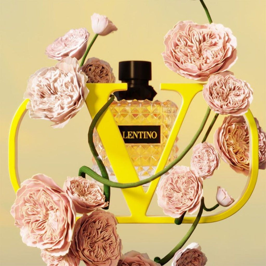 Refect Beauty Valentino Donna Born In Roma Yellow Dream perfume bottle surrounded by pink roses and a yellow V logo