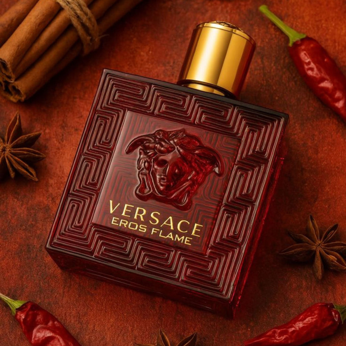 Refect Beauty Versace Eros Flame Eau de Parfum in a red glass bottle with gold cap, surrounded by spices and chili.