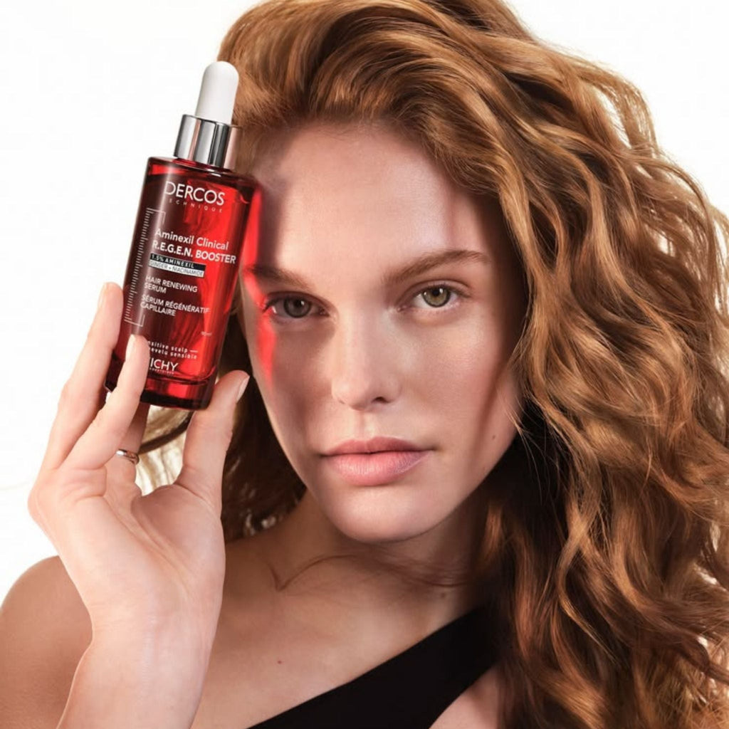 Refect Beauty model holding a red bottle of Vichy Dercos Aminexil Clinical R.E.G.E.N. Booster hair serum