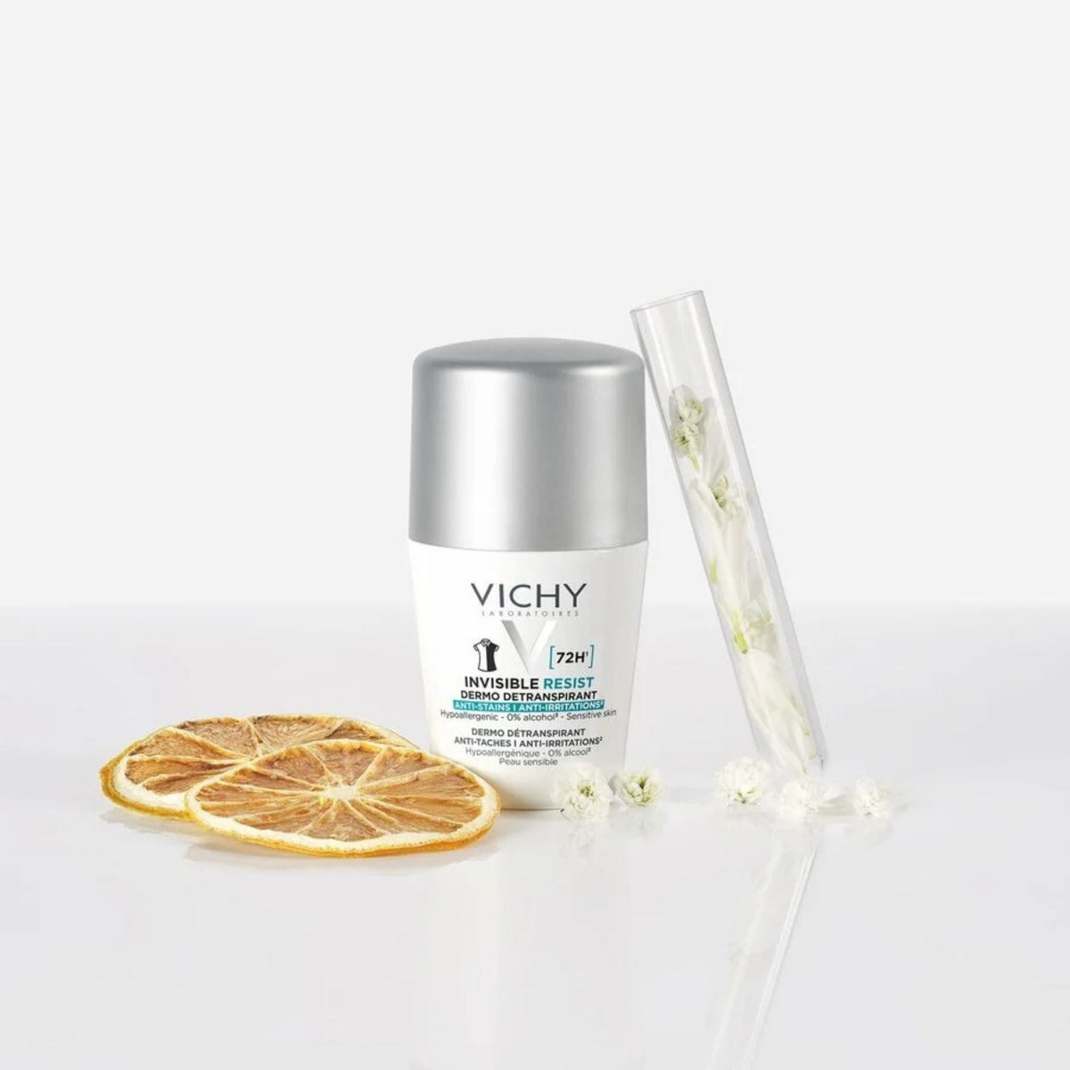 Refect Beauty Vichy Invisible Resist 72H roll-on deodorant with dried citrus slices and white flowers on white surface.