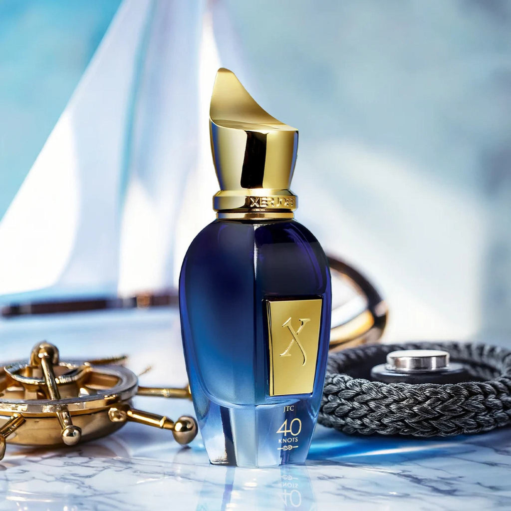 Refect Beauty Xerjoff 40 Knots Eau de Parfum in a blue glass bottle with a gold cap, set against a nautical background.