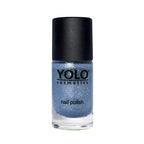 Refect Beauty Yolo glitter nail polish in a shimmering blue shade with a black cap in a glass bottle.