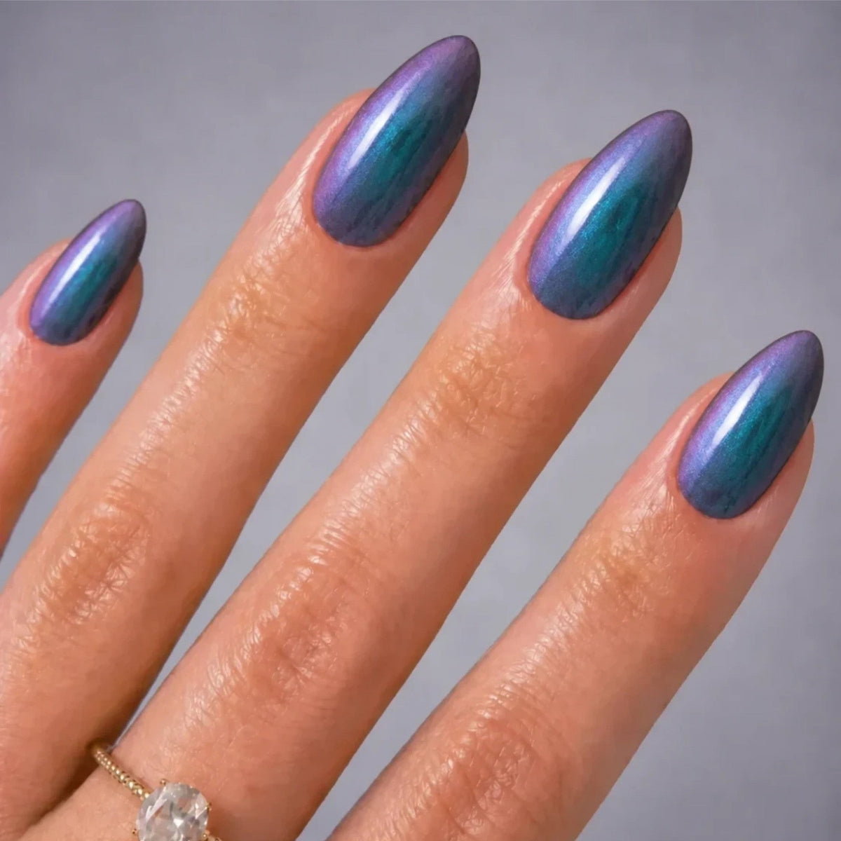 Refect Beauty Yolo Galaxies nail polish featuring a multi-dimensional purple and teal shimmer on almond-shaped nails.