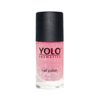 Refect Beauty Yolo pink glitter nail polish in a clear glass bottle with a black cap.