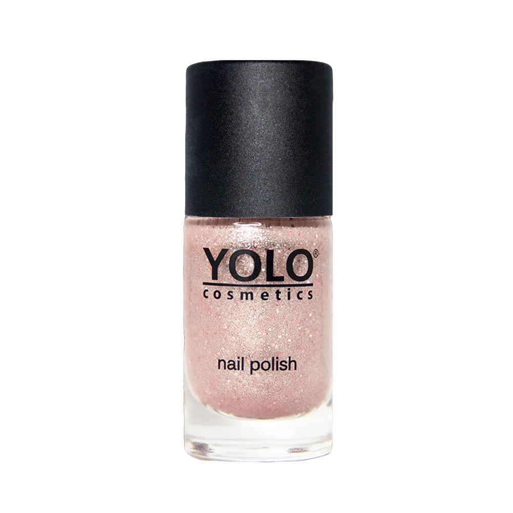 Refect Beauty Yolo glitter nail polish in a soft shimmering pink shade with a black cap in a glass bottle.