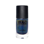 Refect Beauty Yolo glitter nail polish in a dark blue shimmering shade with a black cap in a glass bottle.