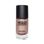Refect Beauty Yolo glitter nail polish in a shimmering metallic rose gold shade in a glass bottle with a black cap.