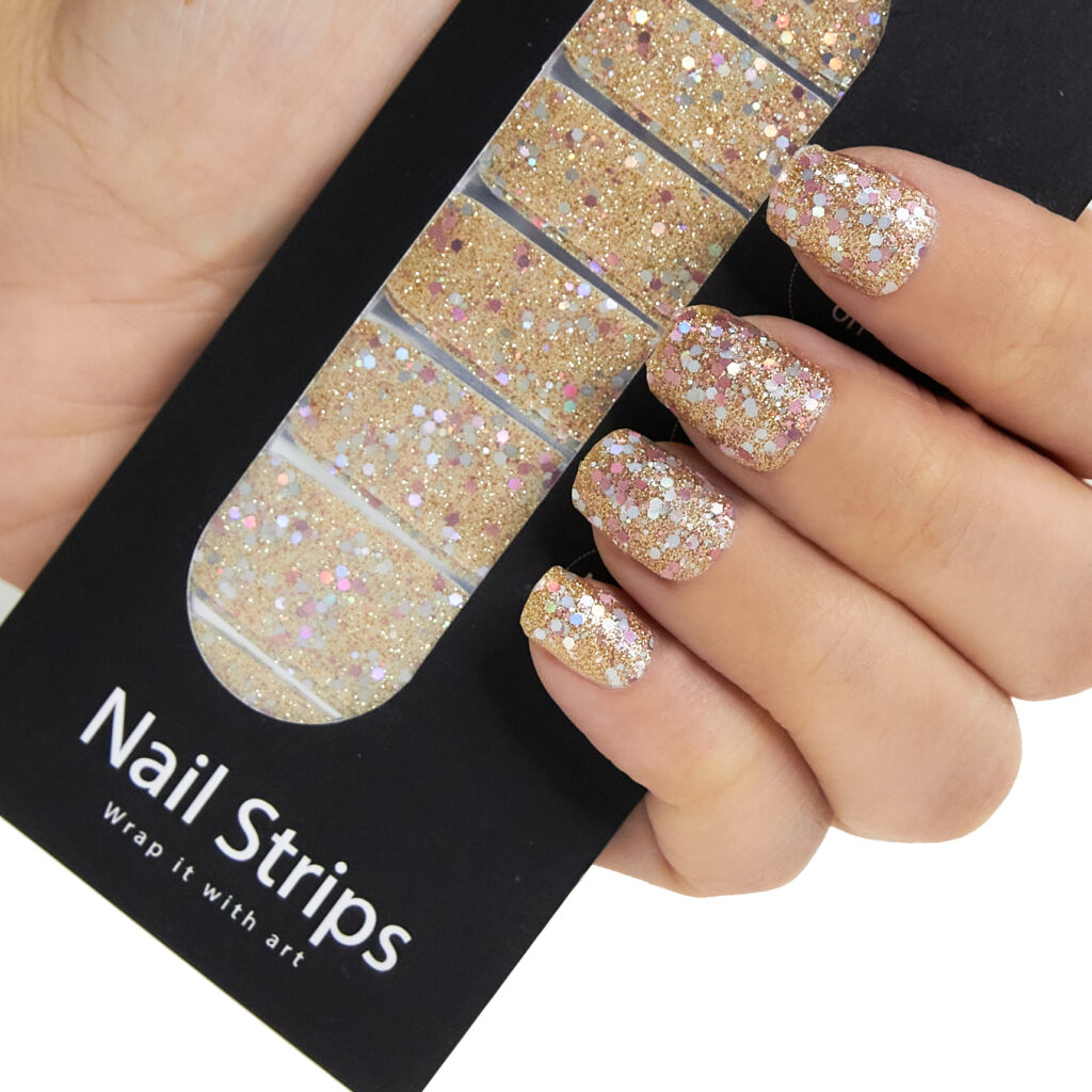 Refect Beauty Yolo nail strips featuring sparkling gold glitter on a hand with a finished manicure