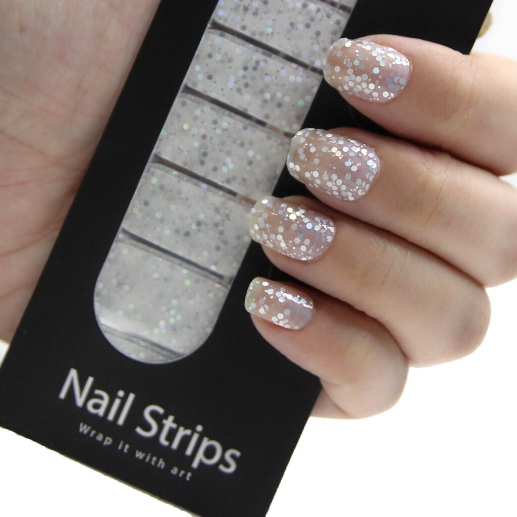 Refect Beauty Yolo nail strips featuring silver glitter designs applied to fingernails for a salon-style manicure