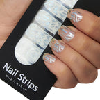 Refect Beauty Yolo nail strips featuring a silver geometric pattern on clear wraps applied to a hand