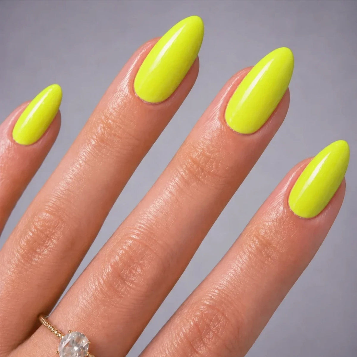 Refect Beauty Yolo Neon nail polish on almond-shaped nails with a vibrant glossy lime green finish