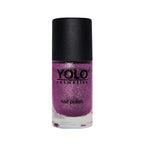 Refect Beauty Yolo glitter nail polish in a vibrant purple shade with a glossy finish in a glass bottle.