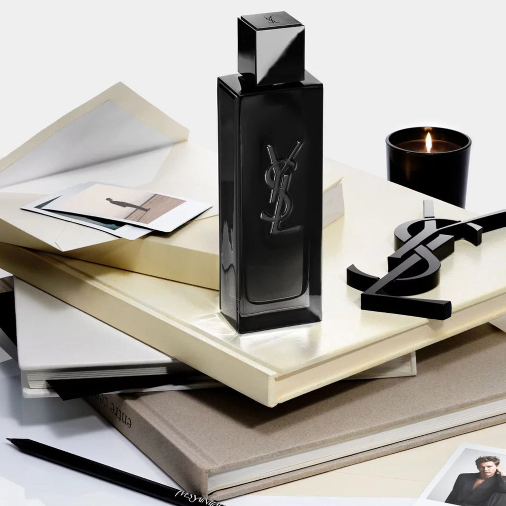 Refect Beauty Yves Saint Laurent MYSLF Eau de Parfum bottle on a stack of books with a candle and YSL logo