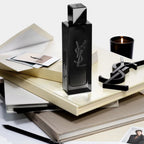 Refect Beauty Yves Saint Laurent MYSLF Eau de Parfum bottle on a stack of books with a candle and YSL logo