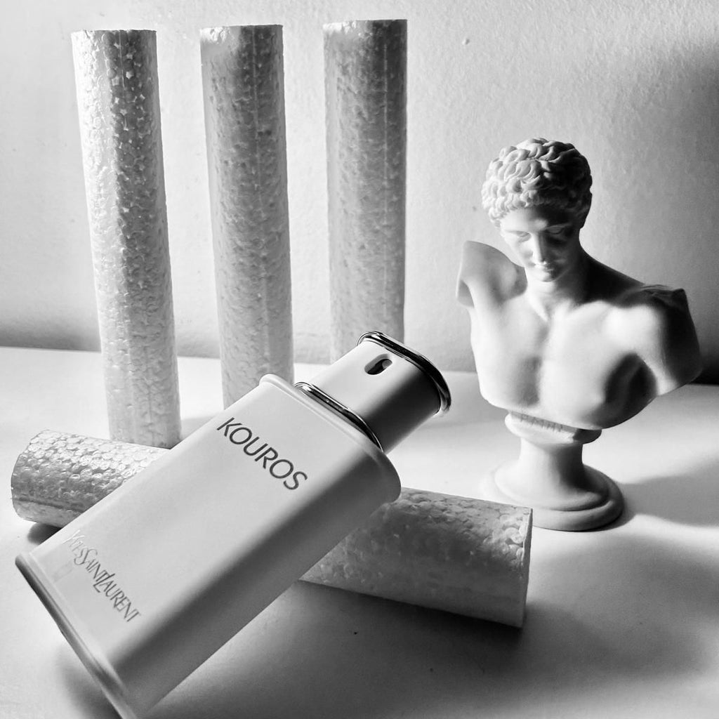 Refect Beauty Yves Saint Laurent Kouros Eau de Toilette bottle displayed next to a classical Greek bust sculpture