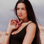 Refect Beauty model holding a bottle of Yves Saint Laurent Libre Berry Crush perfume in a desert landscape