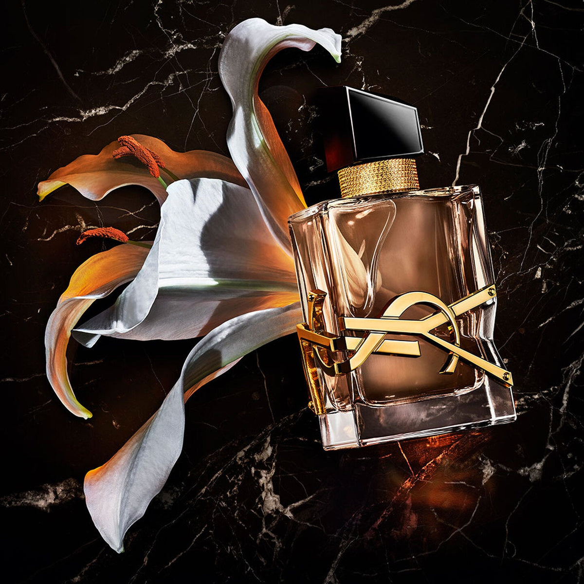 Refect Beauty Yves Saint Laurent Libre Flowers & Flames perfume bottle with a lily on a dark marble background