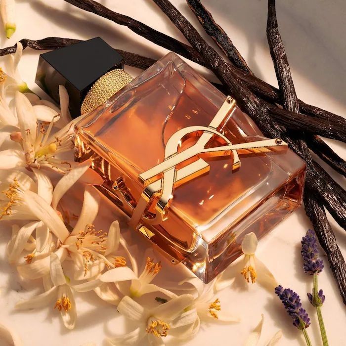 Refect Beauty Yves Saint Laurent Libre Intense perfume bottle surrounded by vanilla beans, orange blossoms, and lavender